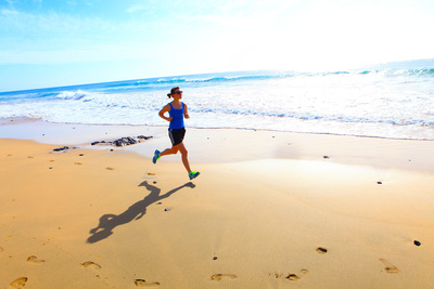 happy and healthy woman running on the beach